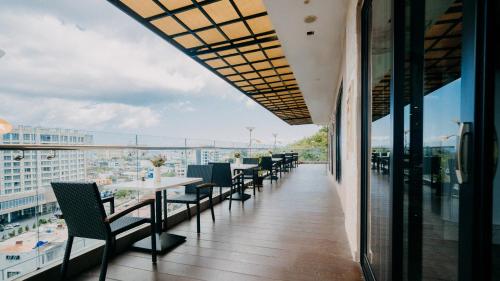 a balcony of a restaurant with tables and chairs at King's Hotel Nagoya Batam in Nagoya