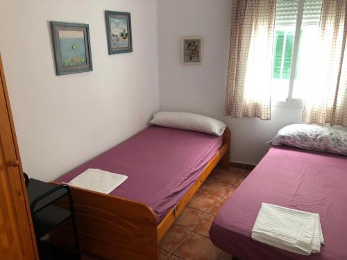 a small room with two beds and a window at CONIL frente a la playa Carril De la Fuente in Conil de la Frontera