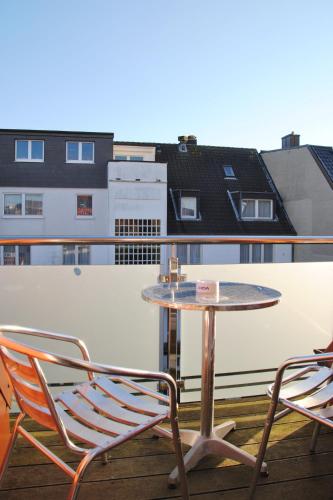 a table and two chairs on a balcony at Nautor Nautor in Norderney