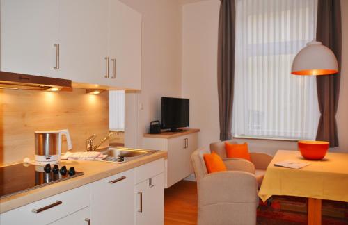 a kitchen with a sink and a table with a chair at Ferienhaus Pauls Ferienhaus Pauls, Whg 03 in Norderney