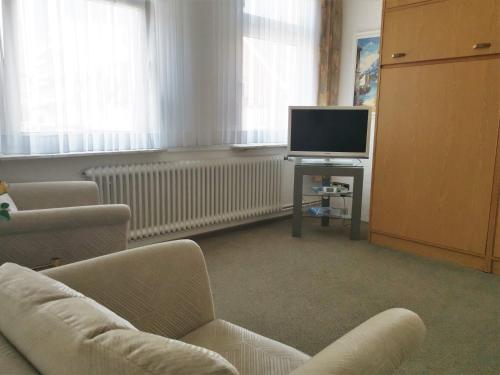 sala de estar con sofá y TV en Haus Mindermann Mindermann 03, en Norderney
