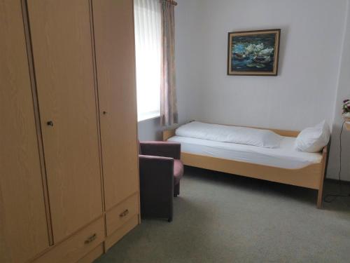 Habitación pequeña con cama y silla en Haus Mindermann Mindermann 03, en Norderney