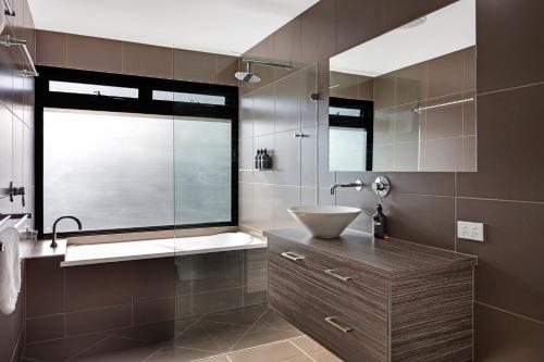 a bathroom with a sink and a glass shower at Forest Haven 2 BR Styled Modern Sanctuary at Maleny in Maleny