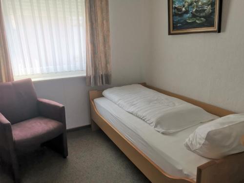 1 dormitorio con 1 cama, 1 silla y 1 ventana en Haus Mindermann Mindermann 03, en Norderney