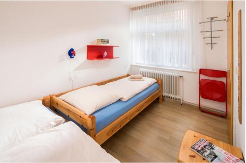 een slaapkamer met 2 bedden en een tafel bij Lüttje Huus Lüttje Huus 02 in Norderney