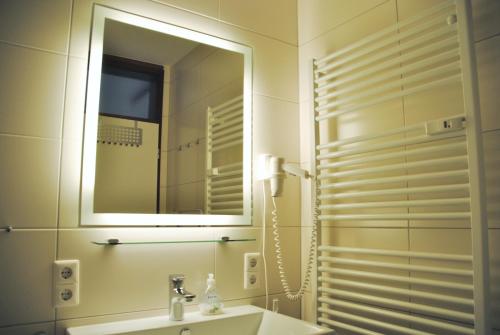 een badkamer met een wastafel en een spiegel bij Reichsadler 11 in Norderney