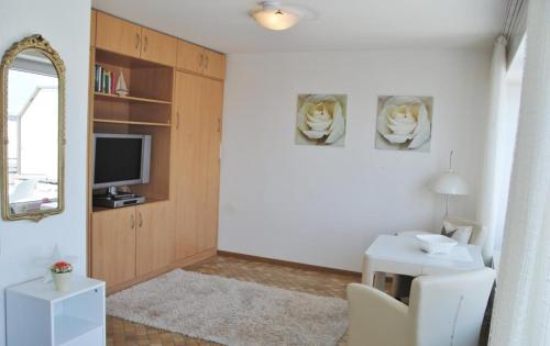 a living room with a desk and a tv and a table at Alte Teestube Alte Teestube 14 in Norderney