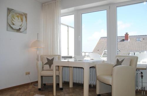a white dining room with a table and chairs at Alte Teestube Alte Teestube 14 in Norderney