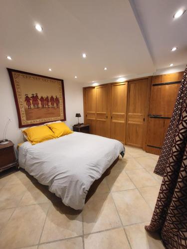 a bedroom with a bed with a painting on the wall at La chapellerie in Caunes-Minervois