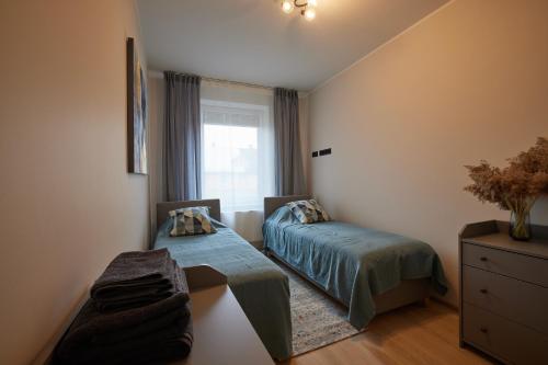 Kastani Apartments في راكفيري: غرفة نوم صغيرة بسريرين ونافذة