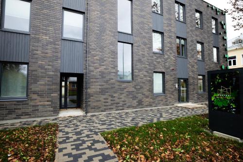 a brick building with a courtyard in front of it at Kastani Apartments in Rakvere