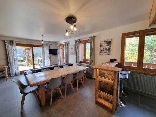 une salle à manger avec une grande table et des chaises en bois dans l'établissement Chalet le Petit Ramoneur, à Châtel