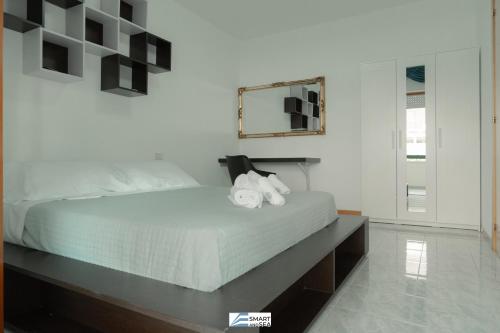 een slaapkamer met een bed en een spiegel aan de muur bij Smart and Sea Gardens in Tortoreto Lido