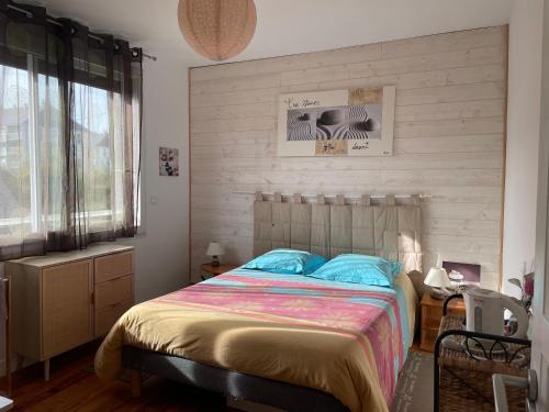 una camera da letto con un grande letto con cuscini blu di Manurêva - Chambre d'hôte en coeur de ville a Dinan