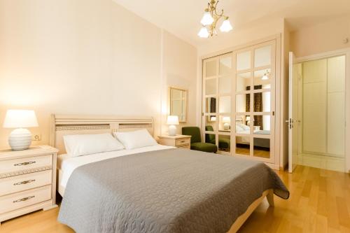 Schlafzimmer mit einem Bett, einer Kommode und einem Spiegel in der Unterkunft Comfy Home III in Tbilisi City