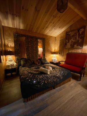 une chambre avec un lit et une chaise rouge dans l'établissement Chalet Valle di Corti, à Pianottoli-Caldarello