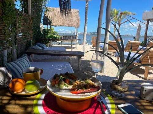 a table with a plate of food and a glass of wine at Mira Mira Beach in Cartagena de Indias