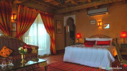 um quarto com uma cama e um sofá em Dar Amoudou em Uarzazate
