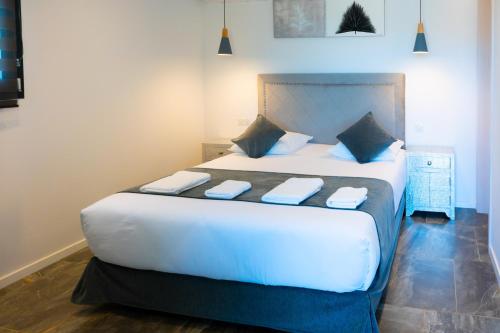 a bedroom with a large white bed with blue pillows at A CASA DI JO in Calenzana