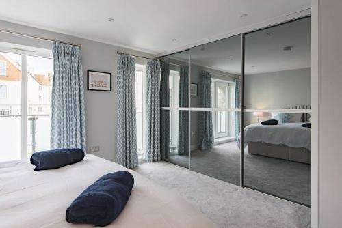 1 dormitorio con cama y espejo grande en Sandy Villa en Westgate on Sea