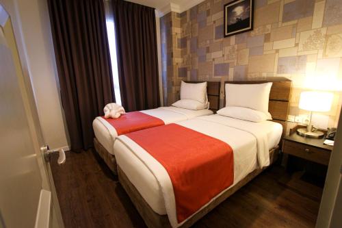 a hotel room with a bed with a stuffed animal on it at Forbis Hotel in Serang