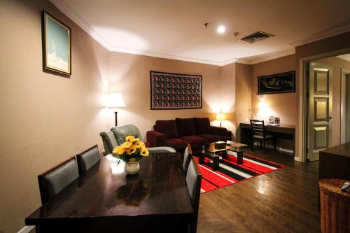 a living room with a table and a couch at Forbis Hotel in Serang