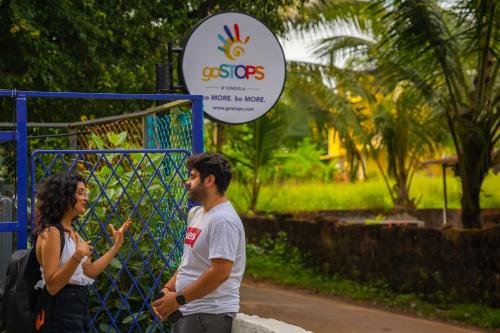 a man and a woman standing in front of a gate at goSTOPS PLUS Goa, Vagator in Goa Velha