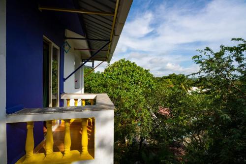 a balcony of a house with a view of trees at goSTOPS PLUS Goa, Vagator in Goa Velha