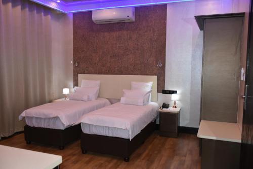 2 camas en una habitación con iluminación púrpura en La Ru, en Mount Moreland