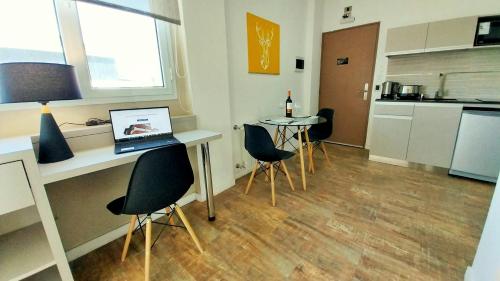 a room with a table and chairs with a laptop at Las Victorias Suites Bariloche in San Carlos de Bariloche