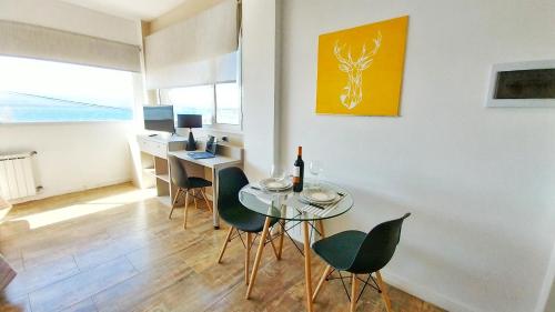 a dining room with a glass table and chairs at Las Victorias Suites Bariloche in San Carlos de Bariloche