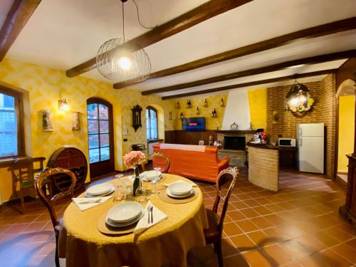 a dining room with a table and a kitchen at La Rosa di Langa - Charming Panoramic House in Albaretto Della Torre 