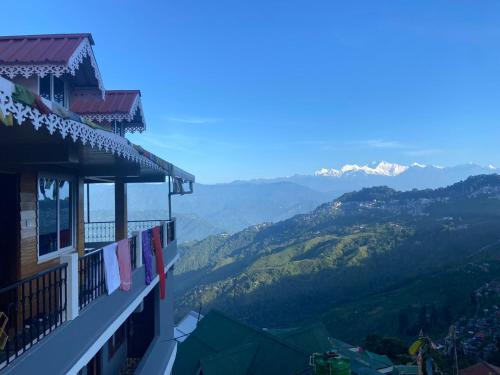 a balcony of a building with mountains in the background at Norbus Homestay in Darjeeling