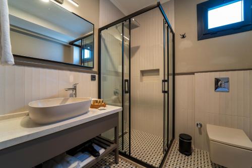 a bathroom with a sink and a glass shower at Ansira Fethiye in Fethiye