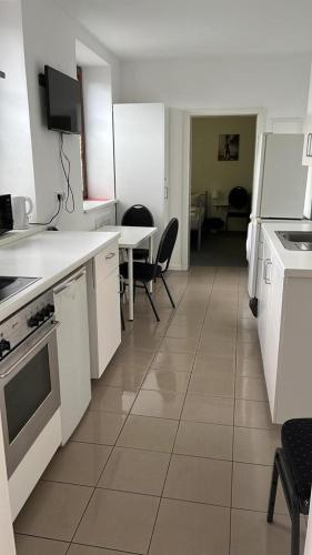 a kitchen with white appliances and a table and chairs at GoldStar Apartments nähe Messe in Sarstedt