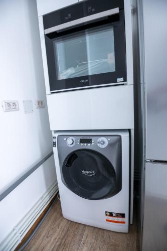 a microwave oven sitting on top of a refrigerator at Apartament CENTRAL in Târgu Jiu