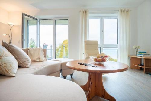 a living room with a white couch and a table at Haus-Seeblick-in-Bosau-Wohnung-4 in Bosau