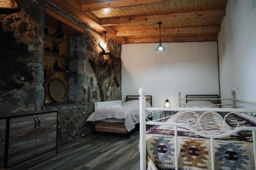 ein Schlafzimmer mit einem Bett und einer Steinmauer in der Unterkunft House 54 in Kazbegi