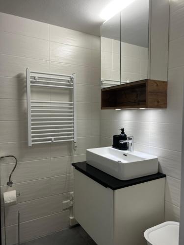 a white bathroom with a sink and a toilet at Superbe studio Anzère, rénové, au pied des pistes in Anzère