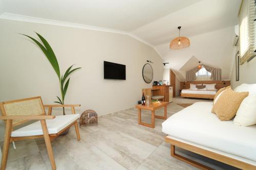 Ansira Suites في فتحية: غرفة معيشة مع أريكة بيضاء وغرفة نوم