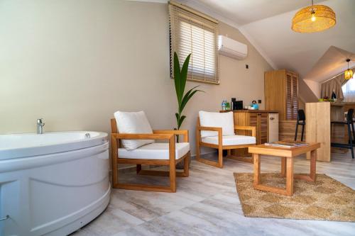 a bathroom with a toilet and chairs and a table at Ansira Suites in Fethiye