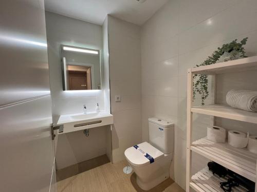 a bathroom with a toilet and a sink and a mirror at Sky Garden & seasonal pool views by ELE Apartments in Málaga