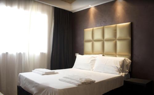 a bedroom with a bed with white sheets and pillows at Leoni Hotel & Private Spa in Citta' Sant'Angelo