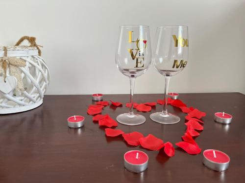 a table with two wine glasses and red paper hearts at Mondo House in Fiumicino