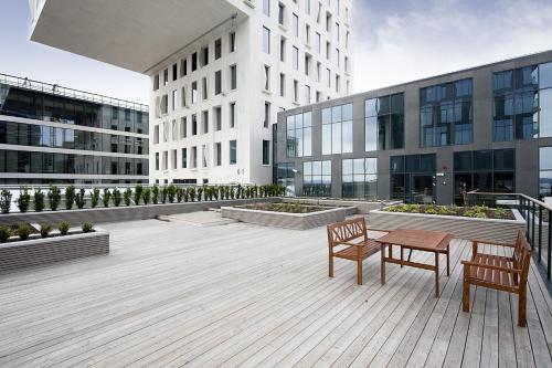a patio with two chairs and a table in front of a building at BJØRVIKA APARTMENTS, Opera Area, Oslo city center in Oslo