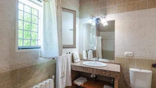 a bathroom with a sink and a toilet and a mirror at Molino de Peralta Pozo Alcón by Ruralidays in Pozo Alcón