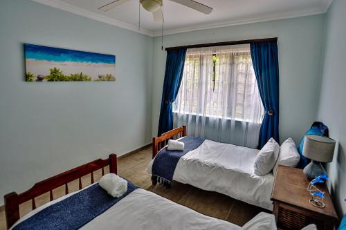 1 dormitorio con 2 camas y ventana en JMK at 49 LaPirogue - Families only, en Ballito