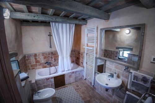 bagno con lavandino, vasca e servizi igienici di At Home In Istria- Villa Stancia Cicada a Žminj