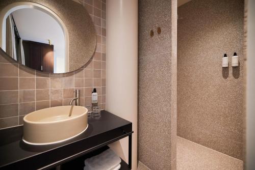 a bathroom with a sink and a shower at Heavens Hotel in Hoorn