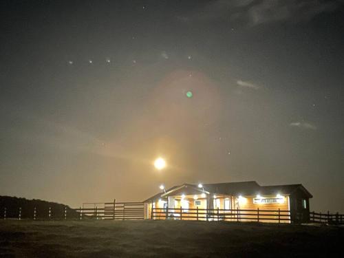 a barn at night with a moon in the sky at Bella casa de campo con panorámica vista al mar in Dalcahue